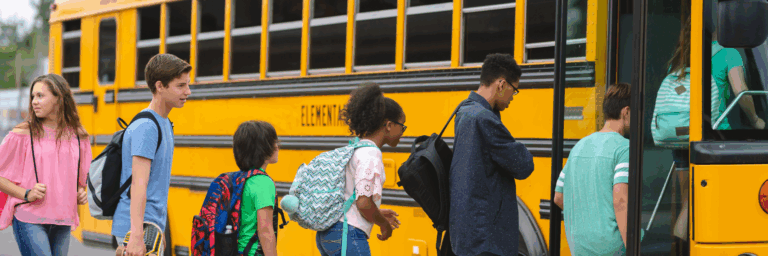 Children of all ages getting on the school bus to go home. High school age children. Smart Tax-Efficient Education Funding Strategies